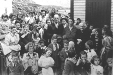 081: Children's party hosted by Tom and Anne Dunphy to celebrate their daughter Mary's  wedding in the States. (1952) [courtesy of Mary (Dunphy) Lamb]  Back row l-r Clarissa Ennis (straight hair), Anita Norman, Teresa Kerrivan (dark coat),  Gwen Carroll holding baby Ron? Ryan, Mary Ennis, Babe Ennis, Anne Counsel (black hat),  Kathleen Barry, Noreen Ryan; 2nd row from back l-r Beth Lambe, Mary Finn, Madonna  Whelan (white kerchief), Rita Whelan (ribbon on hair, looking to right), Madonna  McCarthy (blonde), Mary Reddy, Imelda Ryan (behind Tom Dunphy), Vince Carroll (wide  brimmed hat), unidentified (face over Vince's shoulder), unidentified (behind Vince),  Adrian Ryan (looking from around office corner; adults l-r Tom Dunphy, Anne (Carroll)  Dunphy, Mrs. Stasia Dunphy; behind Stasia l-r Teresa Norman, Willie Barry, Ray Carroll,  Joe Barry (hand on cap brim), Vince Ennis (stripes), Francis Bishop, Joe Rose,two  unidentified girls (kerchiefs, faces not showing); front row l-r Michael Norman,  Winnie Norman holding Brendan Norman, John (or Aloysius) Ryan (blonde behind Winnie),  Veronica Kerrivan ? (black hat), Hilda Whelan (front center), Irene, Ethel and Claire  Webber (matching polkadot kerchiefs), Rita Ennis (by Tom Dunphy's hat), unidentified  (kerchief, face not showing), Sheila Ryan (hand to mouth), Bertha Norman (behind Sheila,  looking left), Carmelita Spurvey (braids, back to camera), Phyllis Whelan (front),  Ethel Lambe (front, far right).  - person named as baby Ron? Ryan, born 1951, also named as Myra Carroll.  - person named as Imelda Ryan also named as Gertrude Ryan.  - person named as Francis Bishop, born 1943, also named as Joe Barry, born 1940,  Charles Norman, born 1939, and Jerome Mulrooney, born 1964.  - person named as Brendan Norman, born 1950, also named as Adrian Norman, born 1944.  - person named as John Ryan also named as Aloysius Ryan.  - person to right of John Ryan has been named as Gertrude Ryan, born 1950, and Eileen  Ryan, born 1950